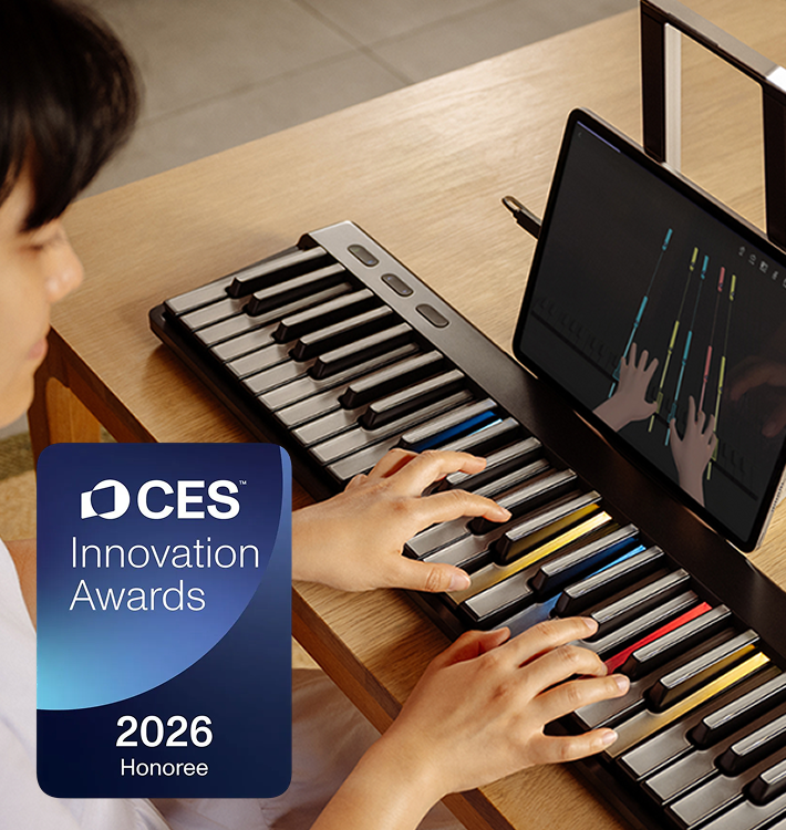 A person playing a ROLI Piano on a wooden desk, with colored key markers and a tablet displaying a virtual hand tutorial, alongside a CES 2026 Innovation Awards badge.